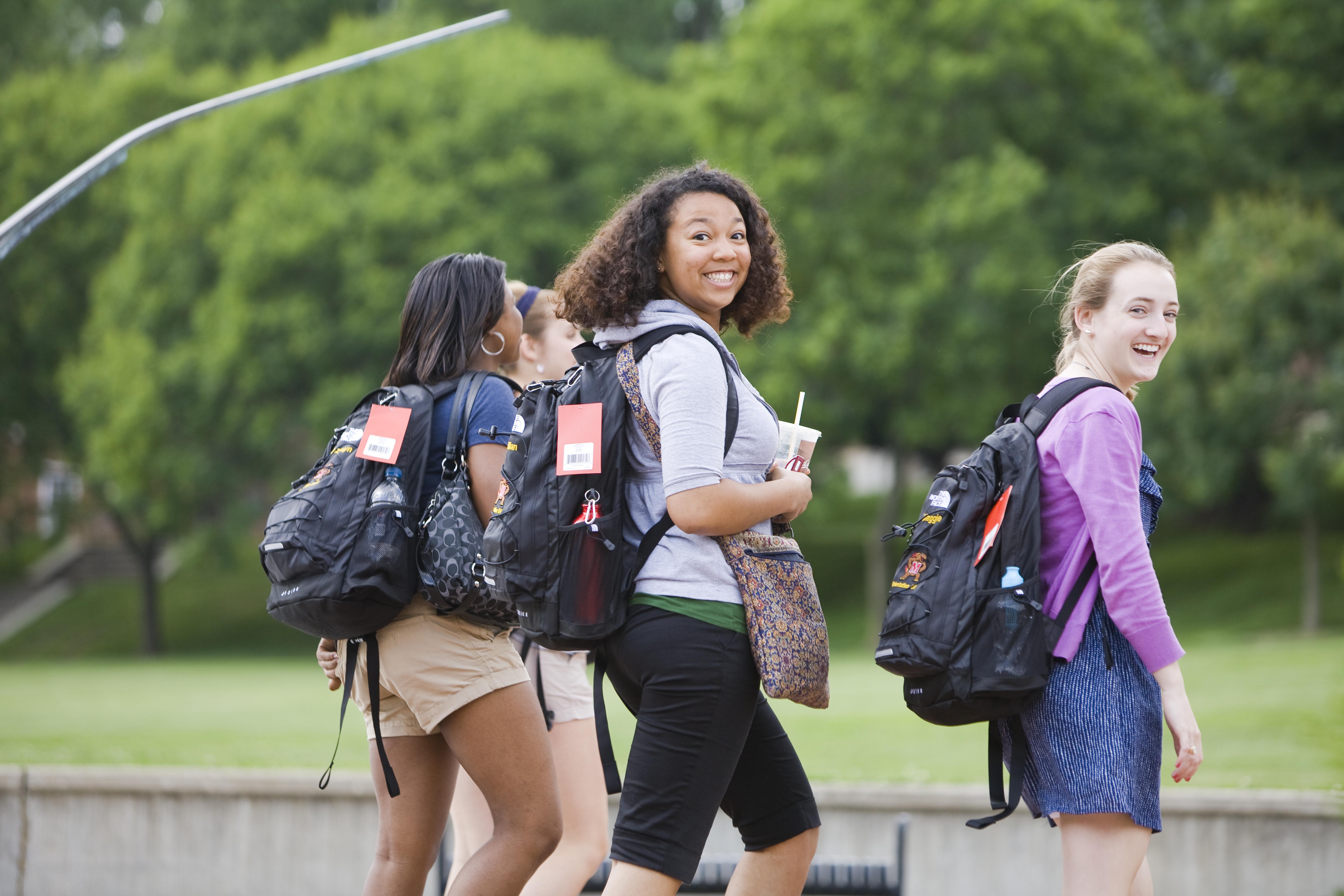 three student walking and smiling at camera